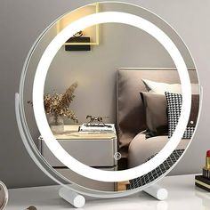 a round mirror sitting on top of a white table