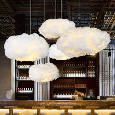 three clouds hanging from the ceiling above a bar