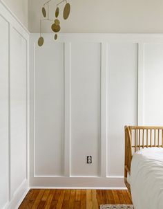 a bedroom with white walls and wooden floors