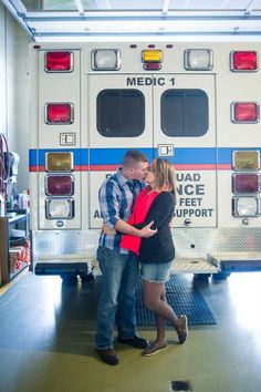 a man and woman kissing in front of an ambulance