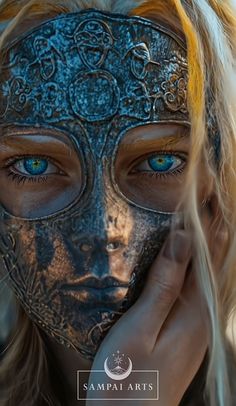 a woman wearing a mask with blue eyes and blonde hair is holding her hand to her face