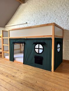 a bunk bed with a green tent on the top and two windows in the middle