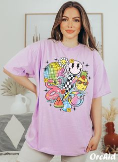 Get ready to rock that casual chic look with our Funny Smiley Face T-shirt ❤️ Get retro with this smiley Graphic Tee! Featuring smiley faces and a nostalgic vibe, this design is perfect for all the cool beach bums out there. Show off your retro style and spread some positive vibes with this fun and funky t-shirt. ❤️ Size up, babe! Go 1-2 sizes bigger for that oversized stunner. Elevate your style, own the spotlight, and unleash your fashion power. It's time to rock the room with your effortlessl Retro T-shirt For Vacation, Funky Tshirts Designs Graphic Tees, Trendy Relaxed Fit T-shirt With Cartoon Print, Playful Graphic Print T-shirt For Vacation, Oversized Purple T-shirt For Summer, Casual Purple T-shirt With Cartoon Print, Casual Relaxed Fit Shirt With Cartoon Print, Casual Tops With Cartoon Print And Relaxed Fit, Casual Cartoon Print Tops With Relaxed Fit