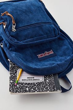 a blue corded bag sitting on top of a book with a pencil in it