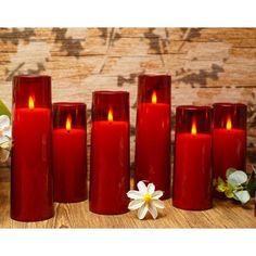 six red candles with white flowers in front of them