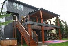 a house with a deck and hot tub in the yard next to stairs leading up to it