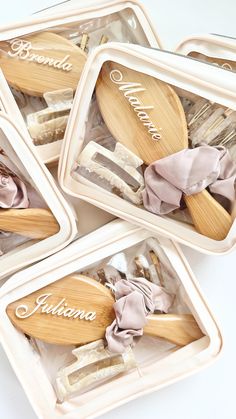 four wooden utensils with name written on them in plastic containers, one is pink and the other is white