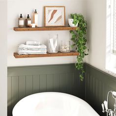 a white bath tub sitting next to a wooden shelf