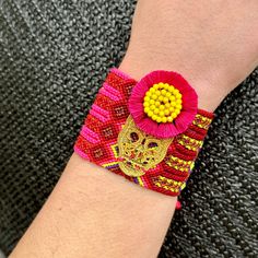 a close up of a person's wrist wearing a bracelet with flowers on it