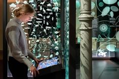 a woman standing in front of a glass display case