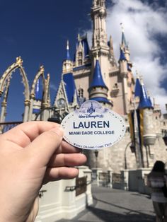 someone is holding up a sticker in front of the castle at disney world that says lauren