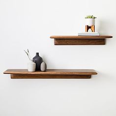 two wooden shelves with vases and books on them