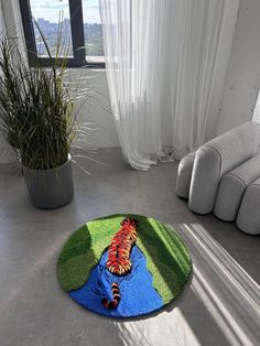 a living room area with a rug, chair and potted plant on the floor