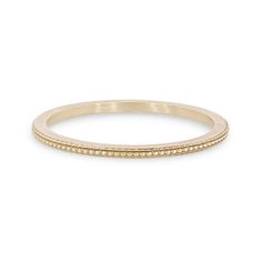 a yellow gold wedding band with small dots on the outside, and a beaded edge