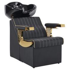 a black and gold barber chair with a bowl on it's backrests