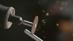 a close up of a metal object being worked on by a machine with sparks in the background