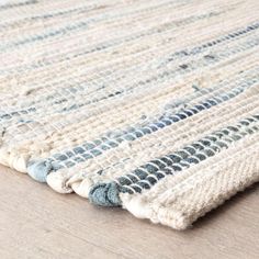 a blue and white rug is laying on the floor next to a wooden table top