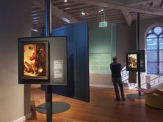 a man looking at paintings in a museum