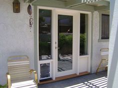 two chairs are sitting on the front porch next to an open patio door with glass panels