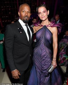 a man and woman in formal wear standing next to each other at an event together