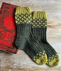 two pairs of socks sitting next to an old book