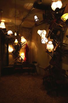 a room filled with lots of lamps and furniture next to a wall covered in lights