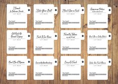 the wedding place cards are laid out on top of a wooden table, ready to be used