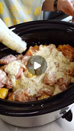 a slow cooker filled with meat and potatoes covered in gravy on top of a table