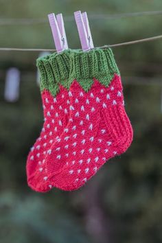 a pair of socks hanging from a clothes line with clothes pins attached to the strings