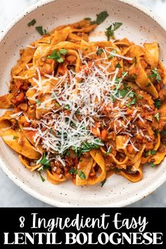 a bowl filled with pasta and topped with parmesan cheese, on top of a marble