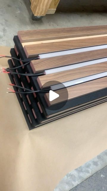 Cory Wasmus on Instagram: "Explore our latest project: walnut slats on black acoustical panels with integrated linear LED lighting. Join us behind the scenes as we prepare this custom wood ceiling and wall project to ship from our workshop in Ohio to destinations across the country! #acousticalpanels #woodwalls #woodceiling #architecturallightingdesign" Wood Panel With Light, Led Slat Wall, Wooden Slat Wall Living Room, Sound Dampening Decor, Ceiling Panels Ideas, Panel Lights Ceiling, Acoustic Panels Wall Design, Wood Cladding Texture, Wood Panel Lighting