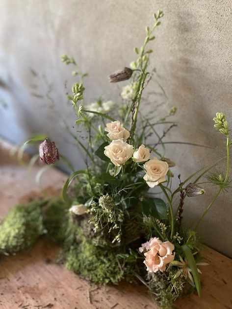 I love these spray roses, fritilaria, larkspur and lisianthus emerging out of the litle mounds of moss. Moss And Floral Centerpiece, Enchanted Forest Floral Arrangements, Moss Floral Arrangements, Moss Tablescape, Moss Arrangements, Moss Centerpiece, Pink Flower Centerpieces, Moss Table Runner, Messy Table