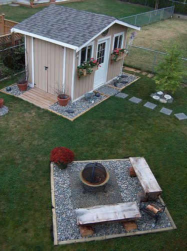 Yard Shed Landscaping, Front Of Shed Ideas, Backyard With Shed Layout, Rocks Around Shed, Fall Shed Decor, Outdoor Shed Decorating Ideas, Landscaping Around Sheds, Shed Sitting Area, Plants Around Shed