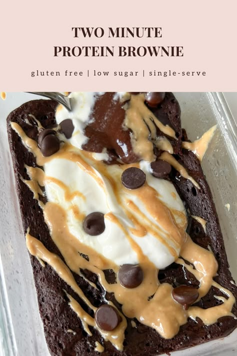 This healthy two minute protein brownie is gluten free, refined sugar free, low carb, low sugar, and high protein. On a small white plate is a single-serve protein brownie in the shape of a rectangle. The outside is a rich dark chocolate color looking soft, gooey in the center, pillowy, and fudgy. Some powdered monkfruit is white sprinkled on top. A fork has a bite on it showing the inside texture of soft, chewy, and airy. Whey Protein Recipes Baking, Hi Protein Low Calorie Snacks, High Protein Quick Dessert, Healthy Snack High Protein, Chocolate Protein Snacks, Gluten Free Protein Brownies, Protein Powder Mug Brownie, Mug Protein Brownie, Baking With Chocolate Protein Powder