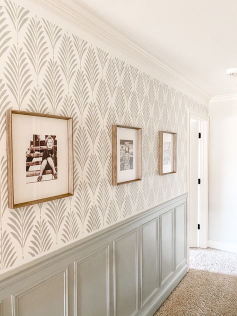 This hallway needed a makeover badly! I chose a stencil from stencil revolution and my husband put up wainscoting. Base color is SW alabaster #hallwayideas #hallwaydecor #wallpaper #frenchcottage #farmhousedecor #gallerywallideas #wainscoting #wainscotingstyles #farmhousedecor #paintcolorideas #frenchfarmhouse Board And Batten Wall Wallpaper Above, Paneled Entryway Foyers, Modern Farmhouse Dining Room Wallpaper, Painted Wanes Coating Wall Colors, Hallway Paint Colors With Wainscoting, Wall Treatments For Hallways, Wallpaper On Bottom Of Chair Rail, Accent Wall Art Ideas, Mural Stencil Wall Paintings