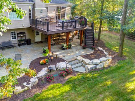 Backyard With Deck And Patio, Patio Under Deck With Fire Pit, Patio Below Deck Ideas, Space Under Deck Ideas, Patio On A Sloped Yard, Under Deck Garden Ideas, Landscaping On A Slope Backyard, Back Deck Patio Ideas, Patio Under Deck Walkout Basement