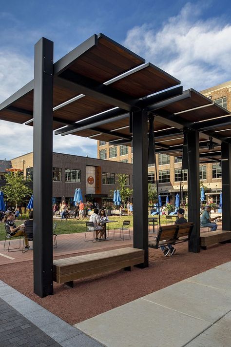 Midtown Plaza along the new Monon Boulevard comes alive on warm summer evenings in Carmel, IN. Studio 431’s custom bench swings and shade structures are hubs of activity as people relax, connect and play in the multi-use urban linear park. #LandscapeForms #customspaces #architectureinspiration Pergola Shade Ideas, Park Shade Structure, Modern Pergola Designs, New Urbanism, Linear Park, Custom Canopy, Covered Walkway, Entrance Gates Design, Modern Pergola