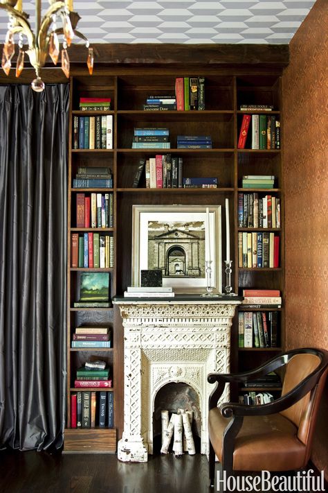 Ornate Fireplace This cast-iron beauty dates back to the Victorian era, so Shon Parker designed the cozy library around it. A Thibaut paper on the walls and a Cole & Son design on the ceiling brings it into the modern age. See more cozy fireplace ideas at HouseBeautiful.com. Georgia Cottage, Library With Fireplace, Library Fireplace, Library Designs, Classic Library, Southern Cottage, Birch Logs, Victorian Fireplace, Library Room