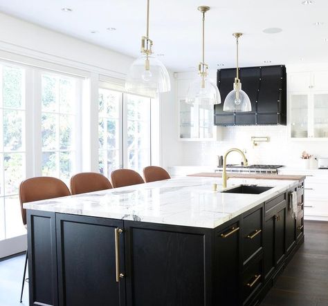 A stunning black oak kitchen island accented with long brass pulls and a white and gray marble countertop is fitted with a stainless steel sink and a brushed gold faucet lit by glass and brass dome pendants. Vermont House, Custom Kitchen Island, Kitchen Post, Black Kitchen Island, Storage Idea, Marble Counter, Divine Design, Kitchen Island Design, Transitional Kitchen