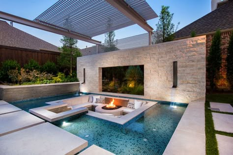 This modern and luxurious swimming pool has a spa with a fireplace, a sunken lounge with a firepit, a cantilevered deck, and floating stepper pads. #SwimmingPool #PoolDesign #LandscapingIdeas #PoolIdeas Sunken Fire Pit, Patio Seating Arrangement, Sunken Patio, Moderne Pools, Sunken Fire Pits, Terrasse Design, Fire Pit Seating, Luxury Pools, Modern Pools