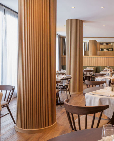 The columns in this modern restaurant's dining room have been wrapped in wood slats, hiding the column within, and turning a potential eyesore into a custom design accent. #RestaurantDesign #Columns #InteriorDesign Round Column Design, Interior Column Design, Column Design Interior, Pillar Design Interior, Column Decoration Ideas, Interior Pillars, Columns Interior, Column Cladding, Column Ideas