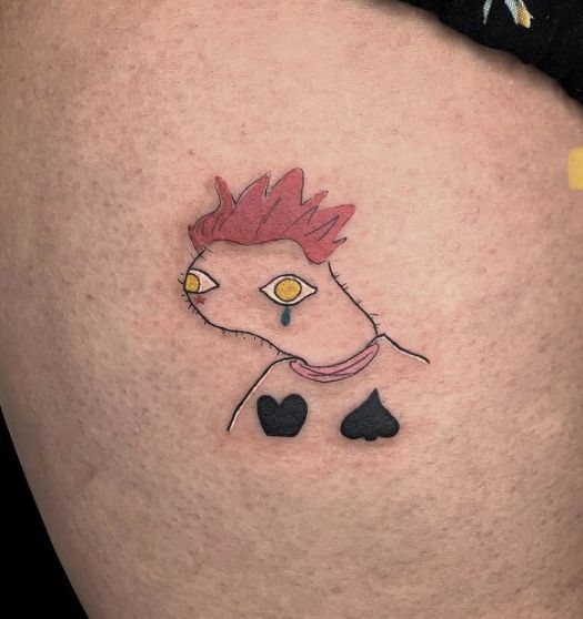 a woman's thigh with a tattoo on it that has an image of a chicken in the shape of a heart