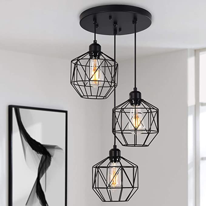 three light fixtures hanging from the ceiling in a room with white walls and black accents