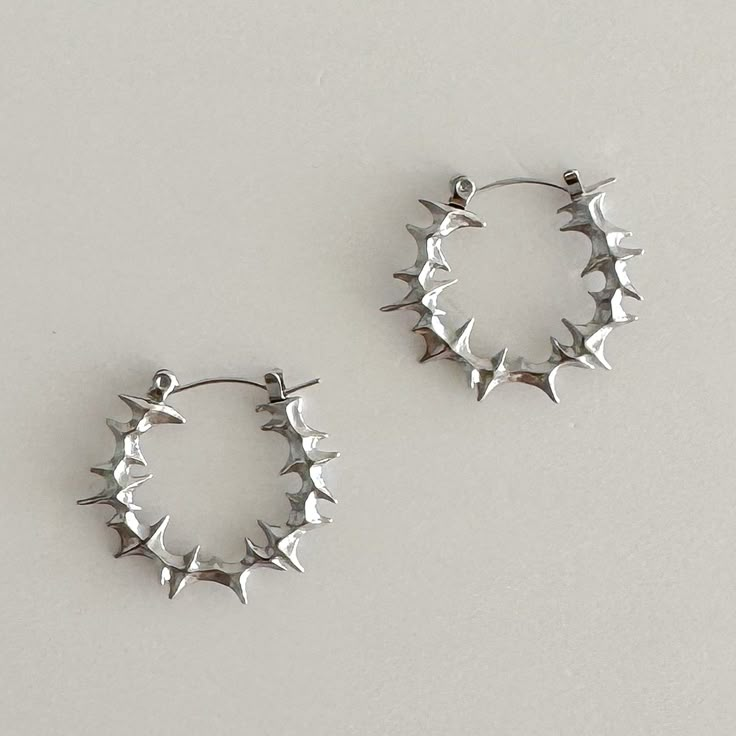 Elevate your style with these bold, spiky stainless steel hoop earrings. 100% stainless steel, 1" diameter. The modern design features small spikes that add an edgy statement to any look. Made from durable stainless steel, these earrings are lightweight and comfortable for all-day wear. Add a touch of contemporary attitude to your ensemble with these standout hoops. We ship in 1-3 days, all purchases come with complimentary jewelry pouch and box. Silver Jewelry Edgy, Silver Alt Jewellery, Gothic Silver Jewelry, Cool Silver Earrings, Classy Silver Jewelry, Silver Earing Stacks, Cute Jewelry Silver, Spiky Jewelry, Cool Earrings Unique