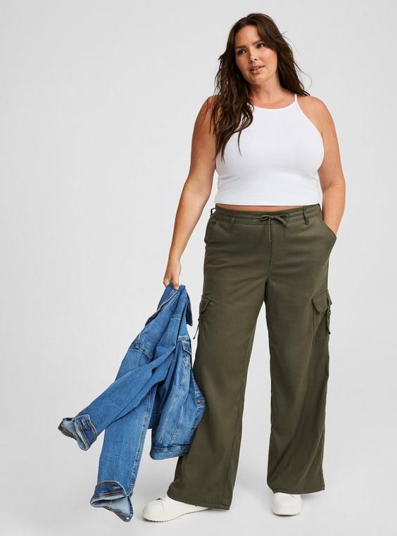 FIT Model is 5'11” wearing size 0. . Mid rise. . Inseam: 30”. . MATERIALS + CARE Drapey twill woven fabric. . 38% cotton, 59% tencel, 3% spandex. Machine wash cold. Line dry. Imported. DETAILS Elastic waistband with drawstring. . Side cargo pockets. . The best plus size women's pull-on weekend wide leg cargo pant pants in deep depths made of twill. Rock your look from Torrid to Festivals like Coachella and Lollapalooza, a concert, a show, or just for fun! Torrid is your destination for cozy fall Cargo Pant, Bottom Clothes, Cozy Fall, Bottoms Pants, Cargo Pants, Woven Fabric, Winter Outfits, Mid Rise, Fitness Models