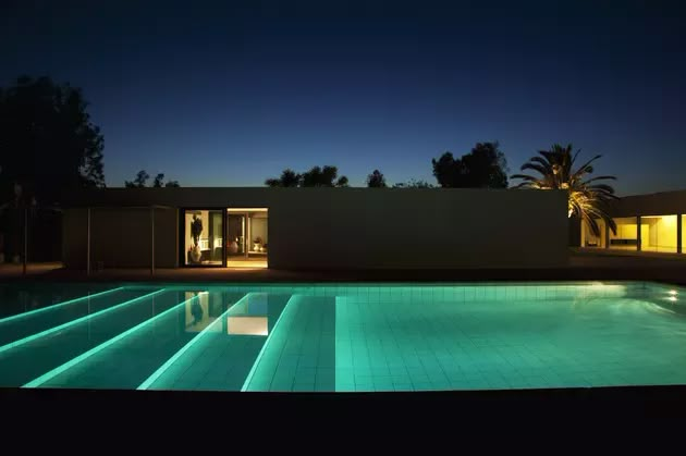 an empty swimming pool at night with lights on