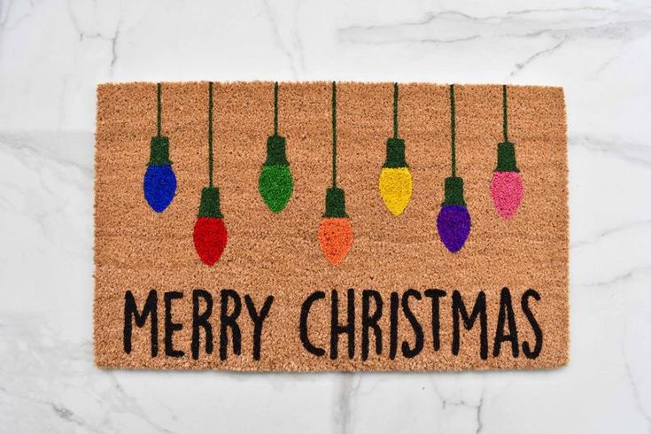 a door mat with christmas lights hanging from it's sides and the words merry christmas