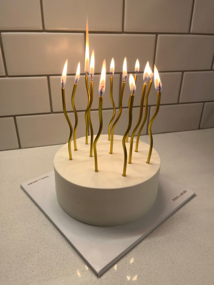 a birthday cake with lit candles on it