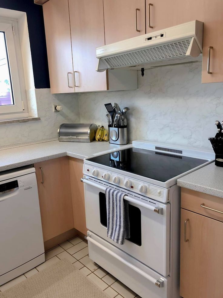 a white stove top oven sitting inside of a kitchen