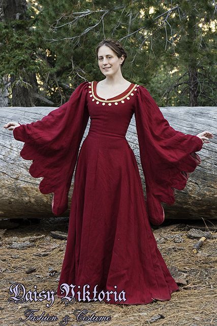 This gown, a tran­si­tional style between a cote­hardie and a houp­pelande, is based on 15th cen­tury Ital­ian sources. The dress is made of red wool and fully lined. The dress laces on the sides with hand sewn eye­lets and hand made fin­ger loop braid. The neck­line is accented with gold silk and span­gles, a pre­cur­sor to mod­ern sequins. The gown is worn here both with braided hair and with a dec­o­rated hat. Loop Braid, Medieval Garb, Medieval Clothes, Queen Costume, Fantasy Dresses, Medieval Costume, Century Clothing, Medieval Clothing, Medieval Dress